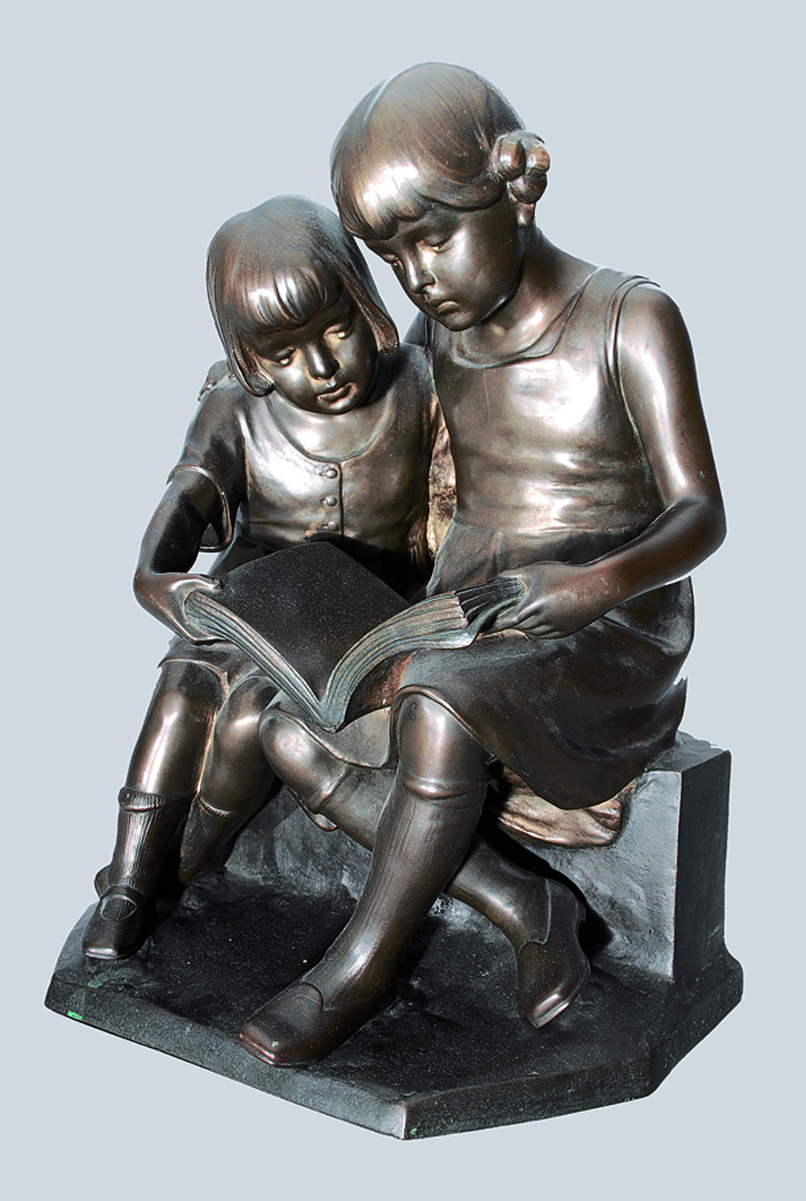 A bronze figure of reading children