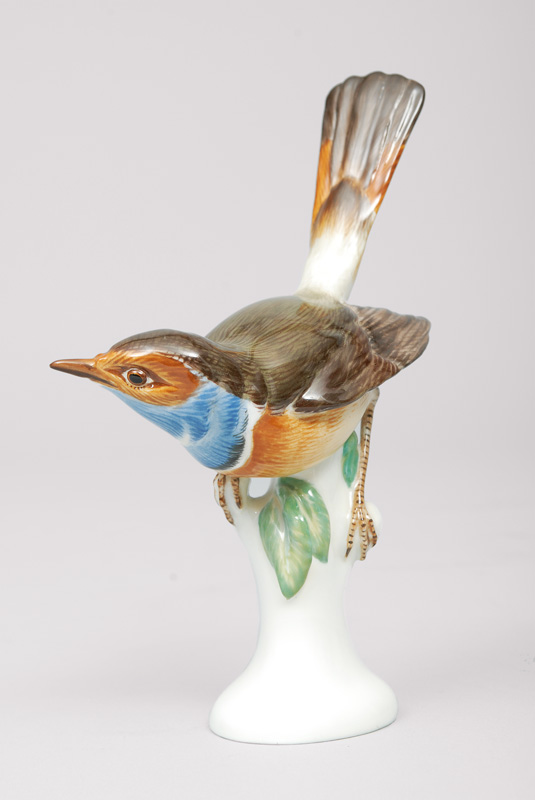 An animal figurine 'bluethroat seated on a branch base'