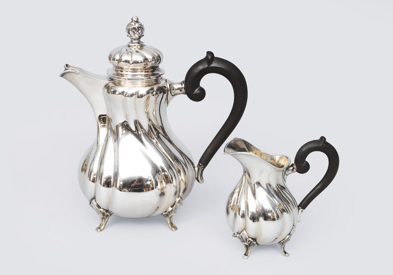 A coffee pot and creamer in style of Chippendale