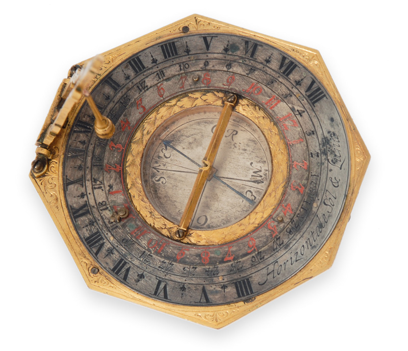 A sun and moon dial with compass