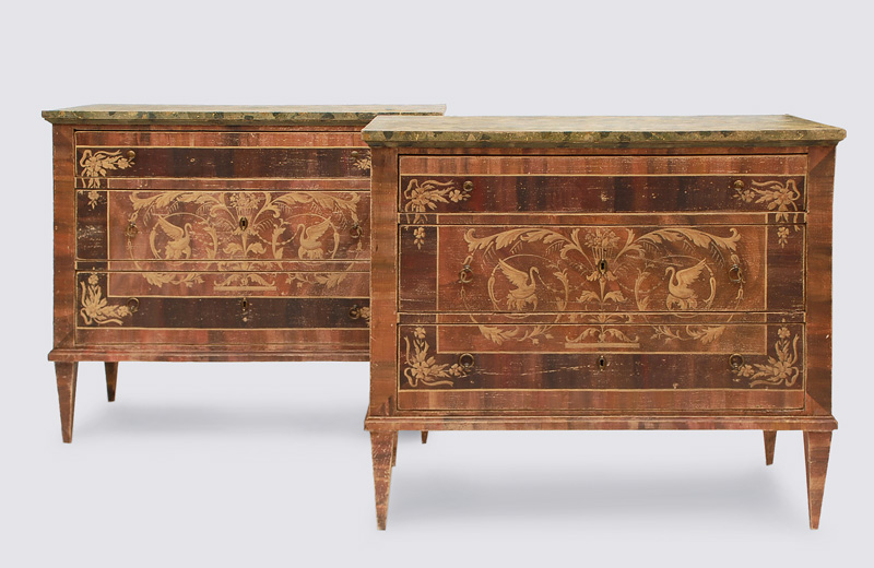A pair of Louis Seize chest of drawers with ornaments of swans and vases