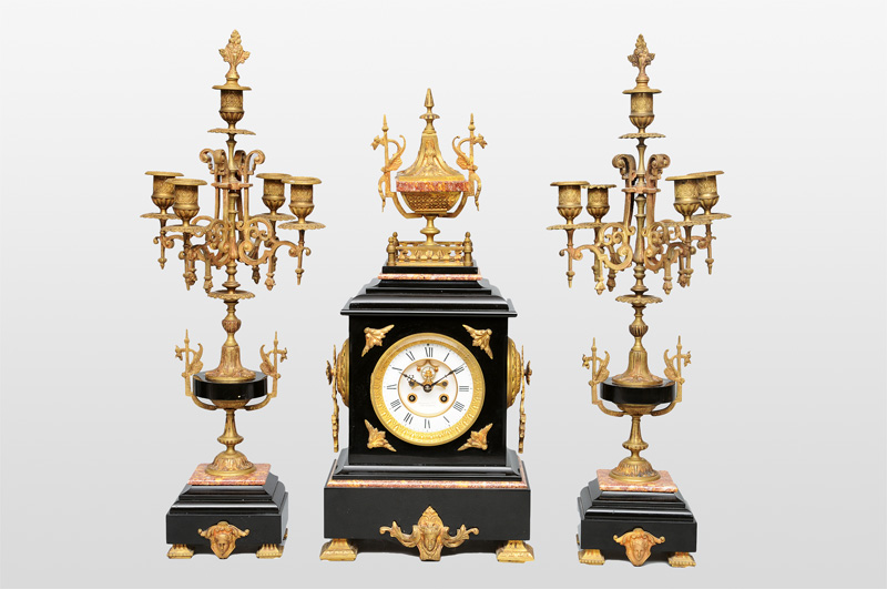 A mantle clock with two candle holders