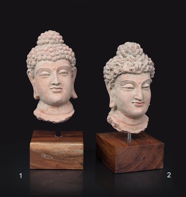A terracotta head of a buddha with curled hair