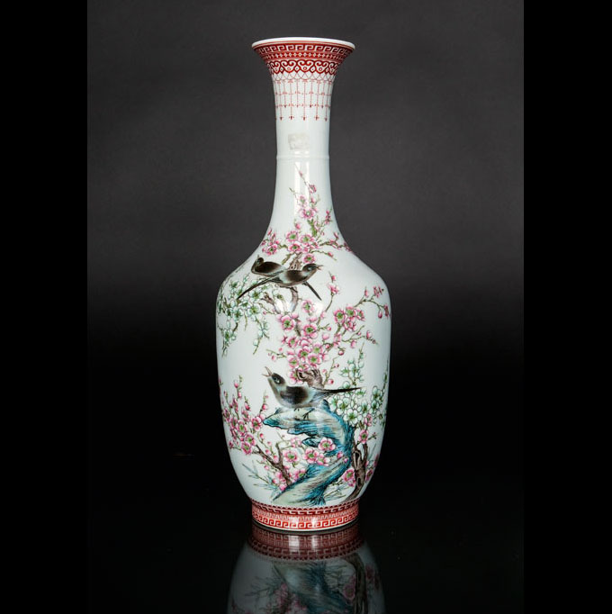 A vase with brids and prunus flowers