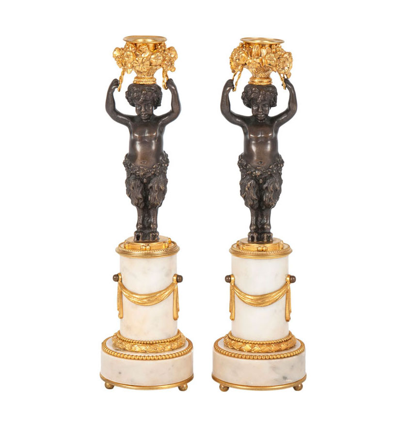A pair of bronze candlesticks with small satyr-figure