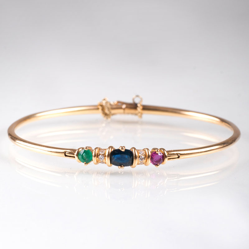 A petite golden bangle bracelet with precious stones