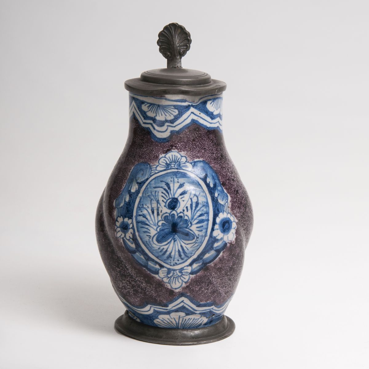 A small pear-shaped jug with speckled ground and blue painting