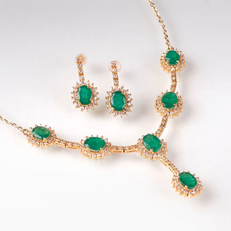 An elegant emerald diamond necklace with a pair of earrings