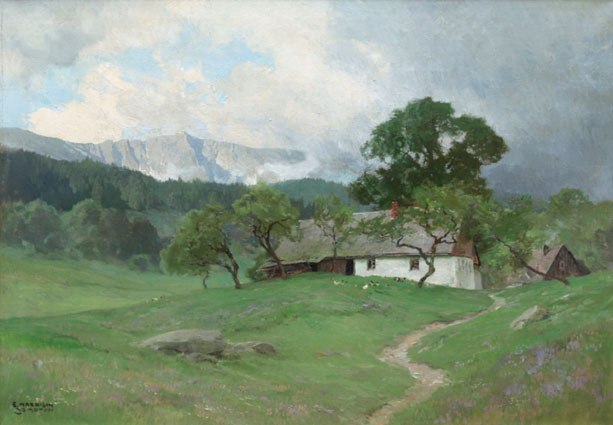 View of a green valley and farmhouses, rocky mountains beyond