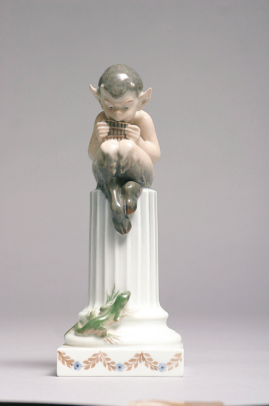 A figure if a faun with lizard in a column'