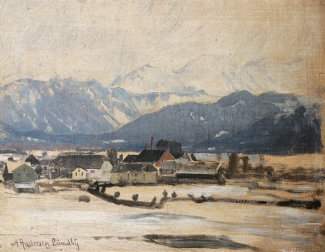 A bavarian winter landscape with a village and snowcovered mountains beyond