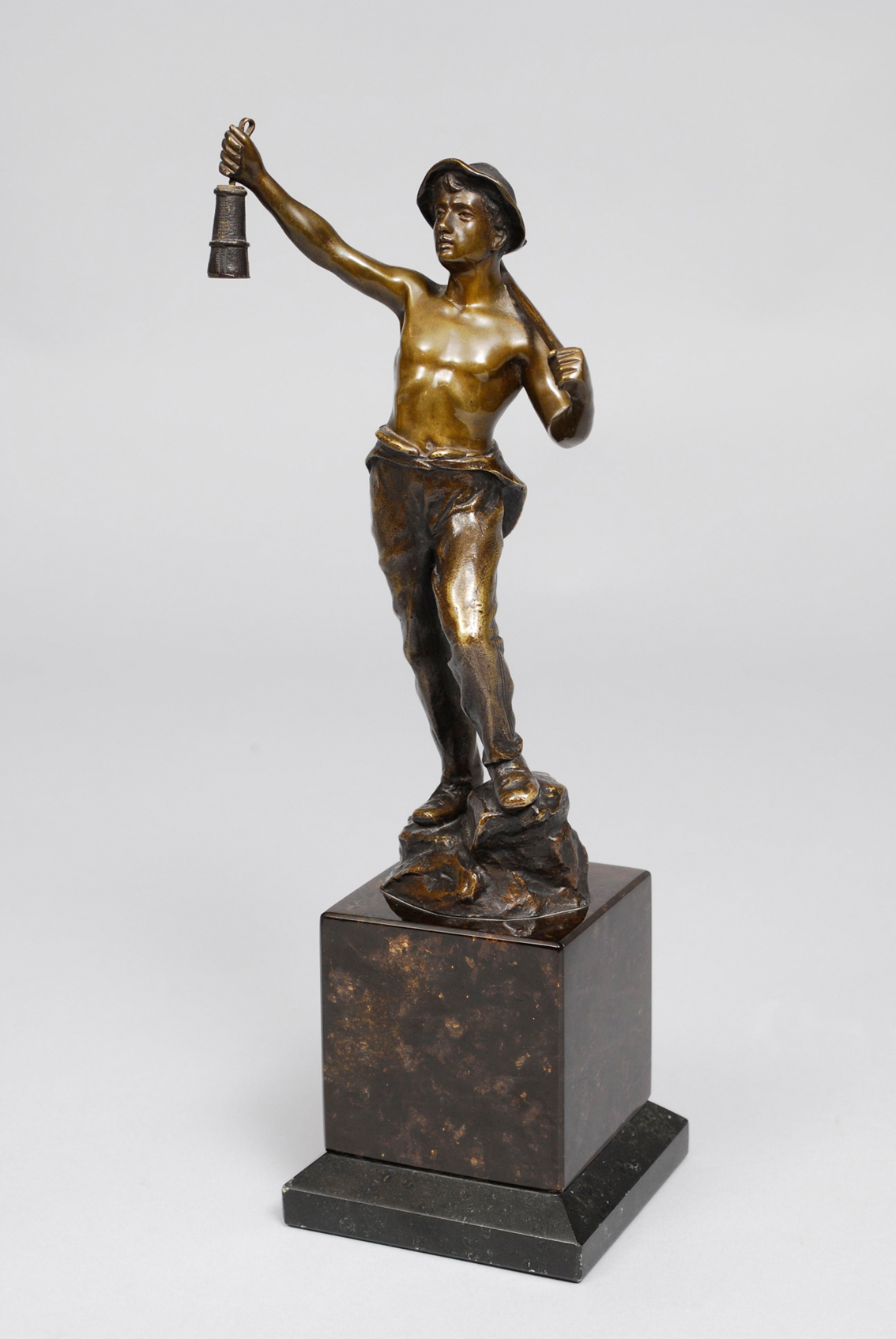 A small bronze figure of a young miner