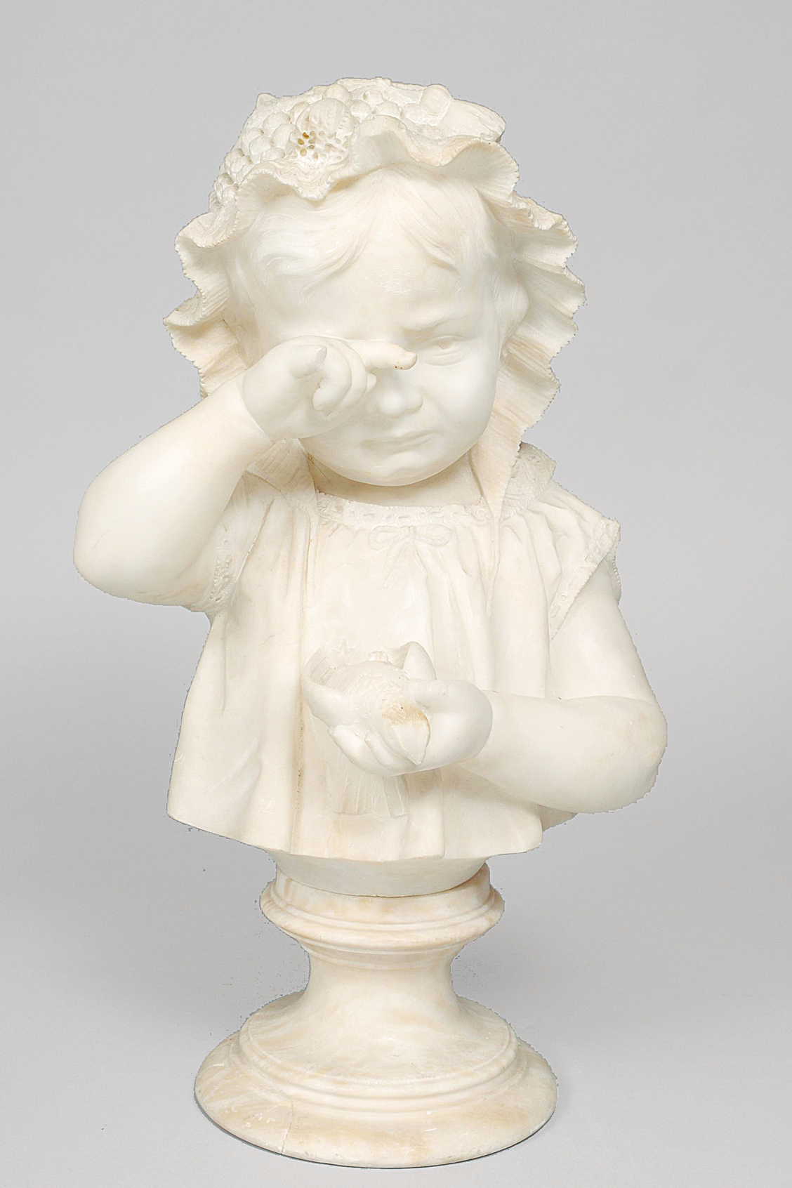 An alabaster bust of a sad girl