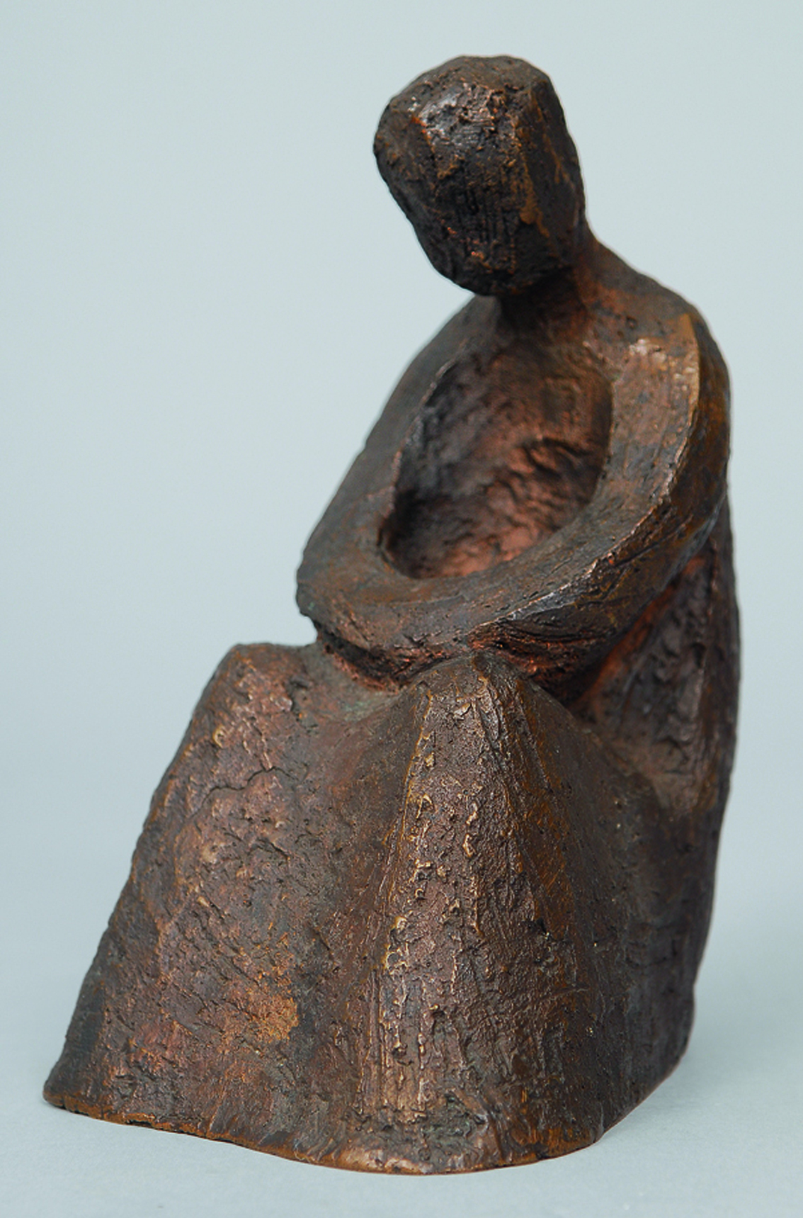 A bronze figure of a reading man