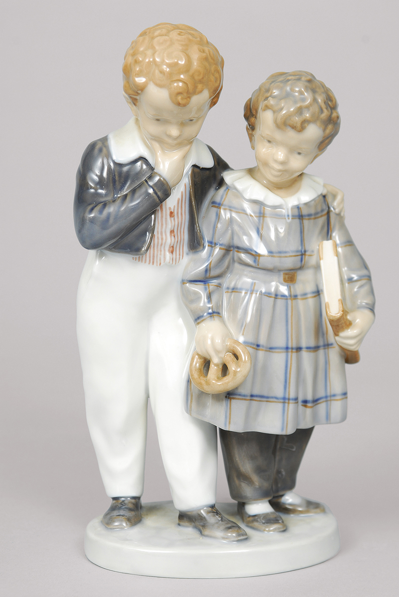 A figure group of 2 children with a prezel