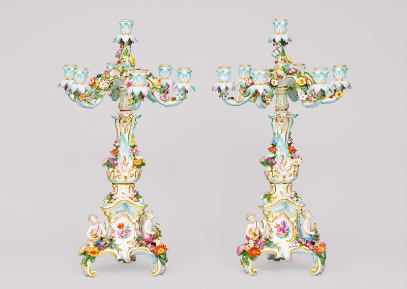 A pair of seven-armed flambeaux with applied putti and flowers