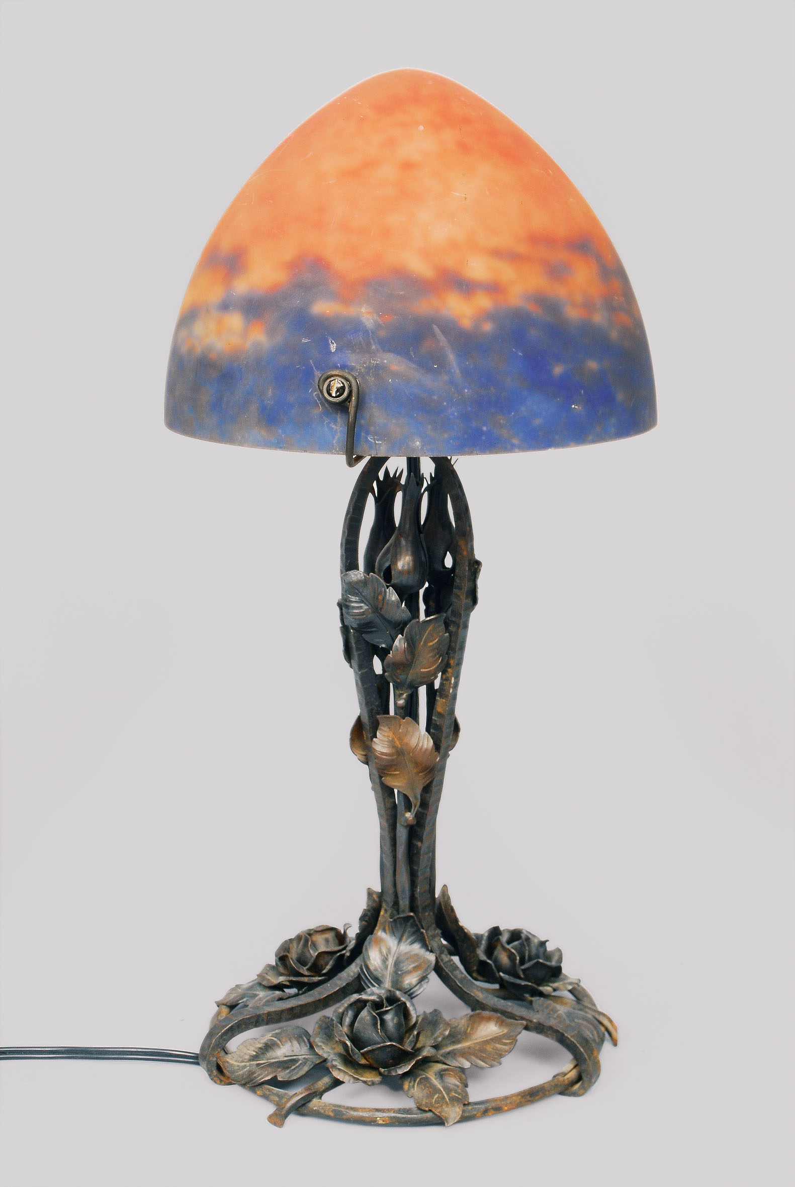 An Art-Nouveau lamp on wrought-iron foot