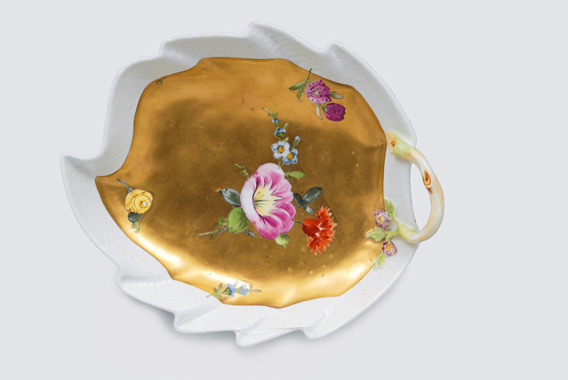 A gold grounded leaf-shaped bowl with flower decoration