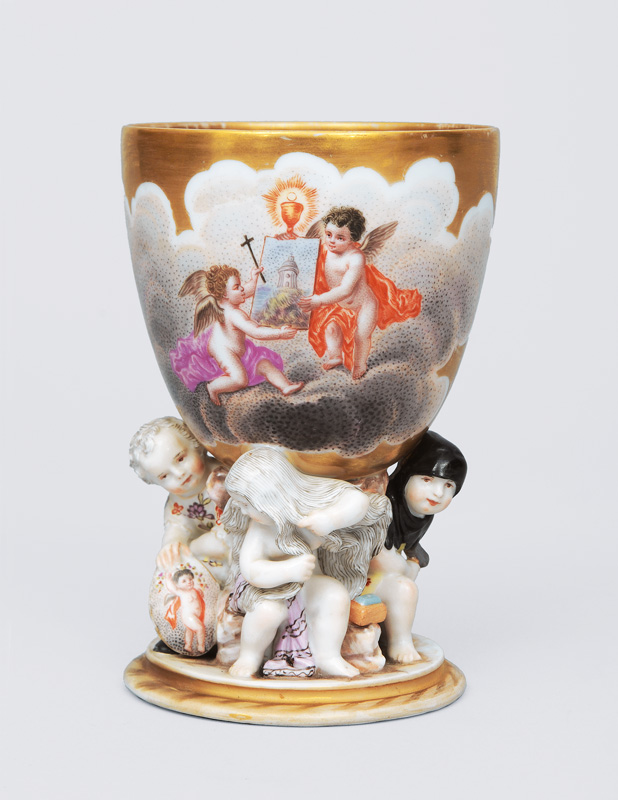 A gold groundet goblet with angel decoratin