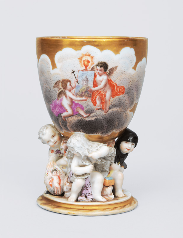 A gold groundet goblet with angel decoratin