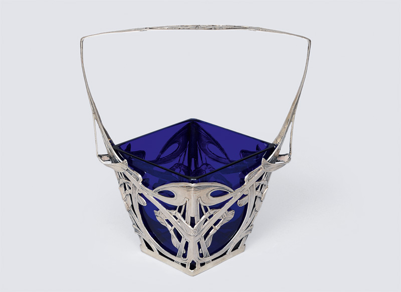 An Art Nouveau basket with blue colored glass insert