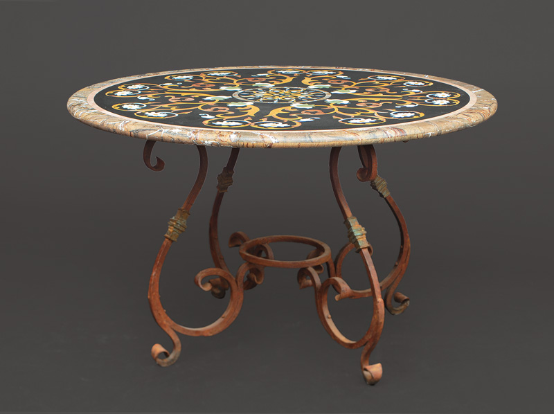 A richly decorated marble table on iron base