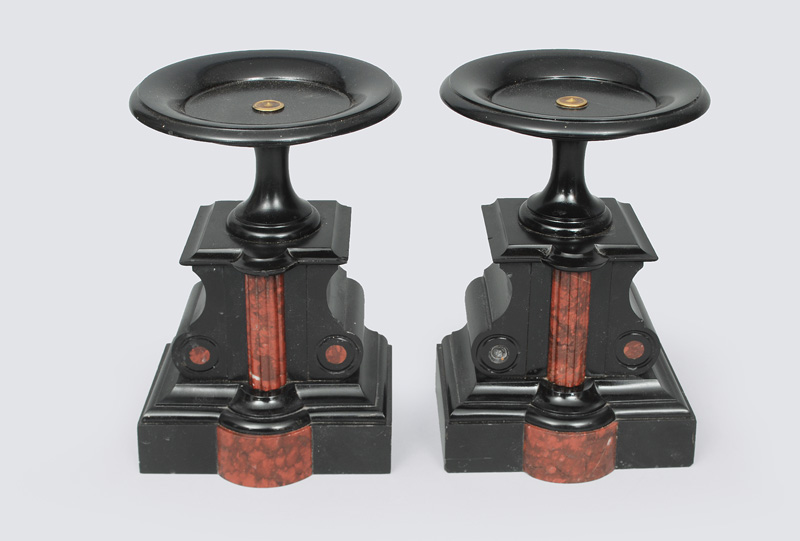 A pair of black fireplace consoles