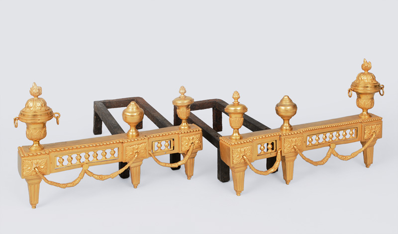 A pair of fire andirons with ornaments of Louis-Seize