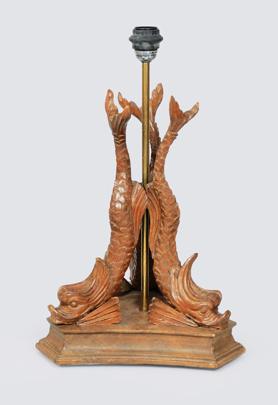A wooden lamp stand with dolphin decor
