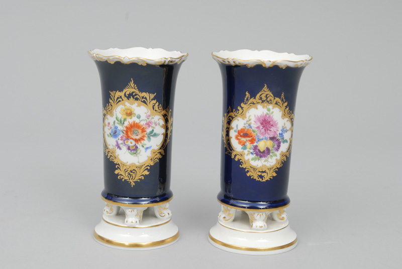 A pair of vases with cobalt blue ground, gilded relief cartouches and bouquet pa