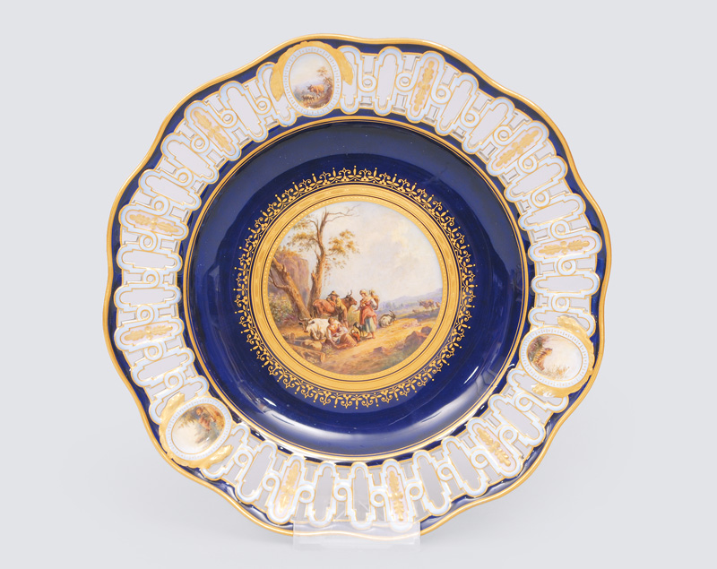 - An openwork plate with cobalt blue ground and a fine painted herdmen scene An openwork plate with cobalt blue ground and a fine painted herdmen scene