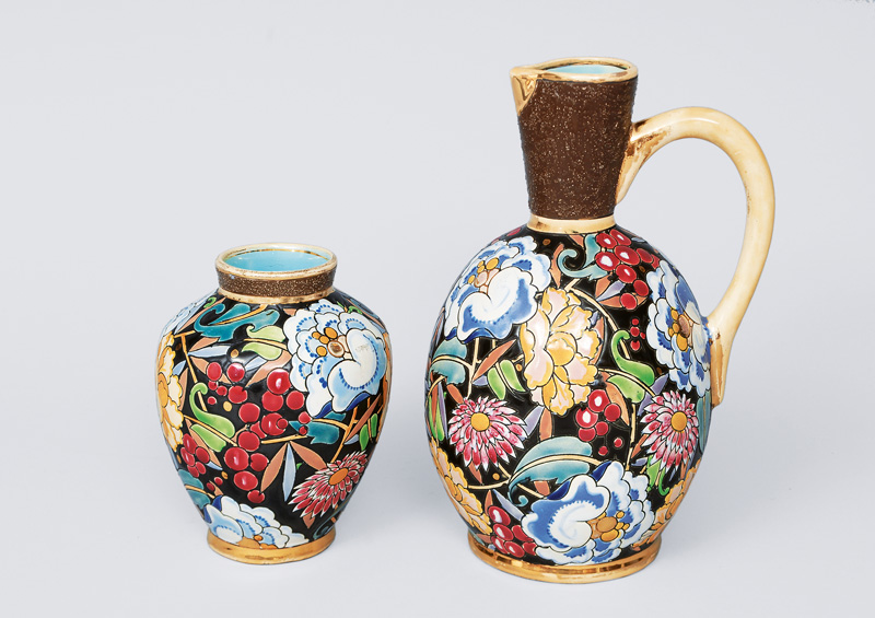 A pitcher and vase with flower and fruit decoration