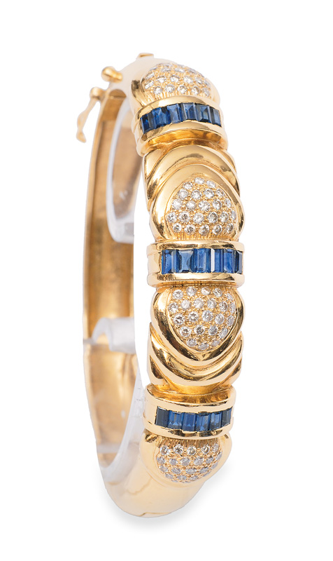 A golden bangle bracelet with sapphires and diamonds
