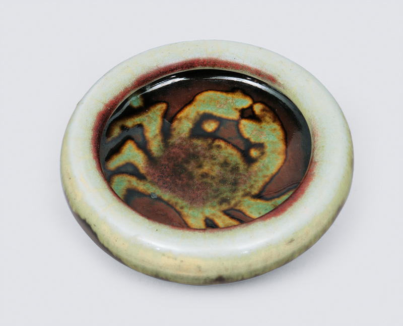 A small flat bowl with crab decoration
