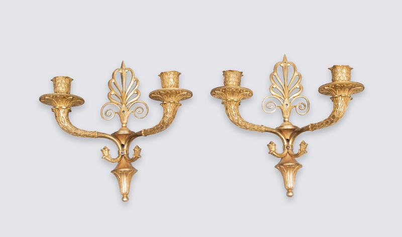 A pair of wall lights in the style of Empire