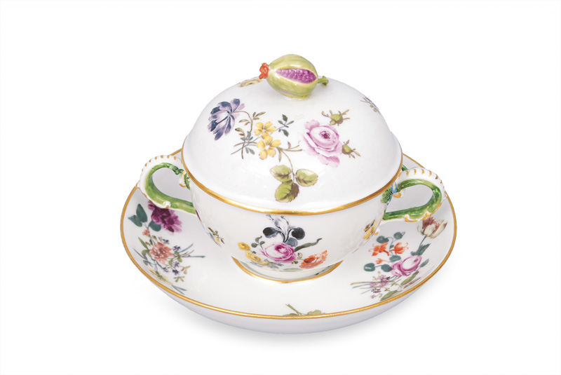A small tureen on saucer decorated with flower pattern