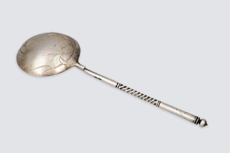 A spoon with carved decor of stylized blossoms