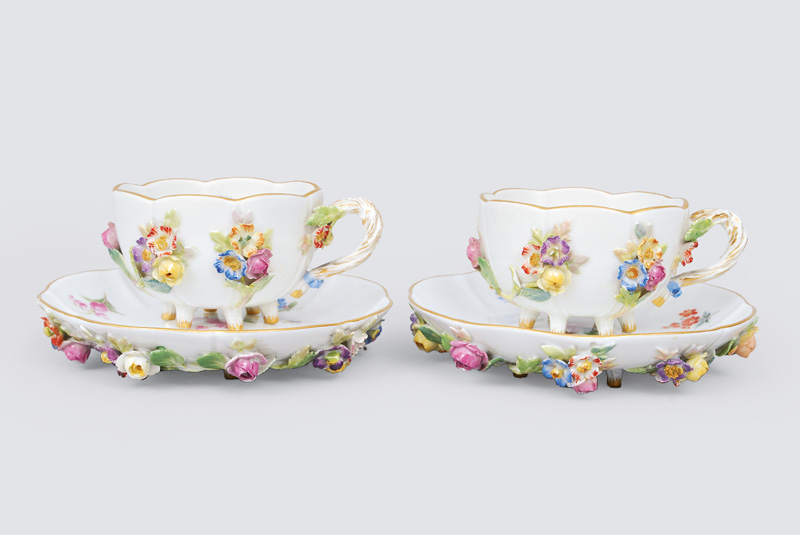 A pair of cups with applied flowers