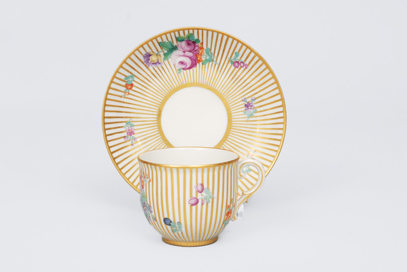 A mocha cup with gold stripes and flower painting