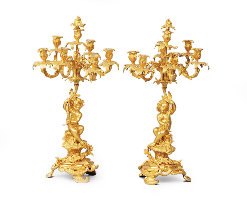A pair of splendid candle holders with putto figures