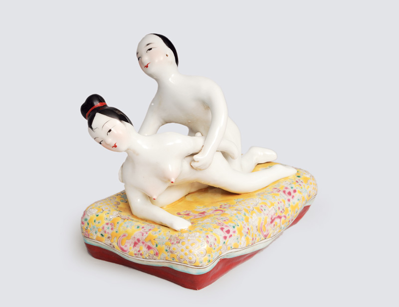 An erotic figurine group on a bed
