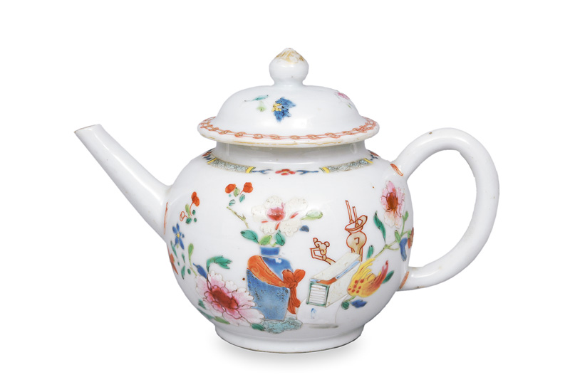 A small teapot with flower painting