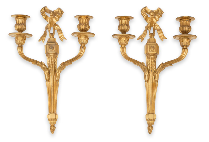 A pair of elegant wall lights with crowned bows