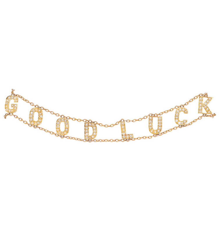 A golden necklace with small pearls "Good Luck"