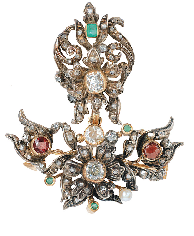 An antique flower brooch with diamonds and emeralds