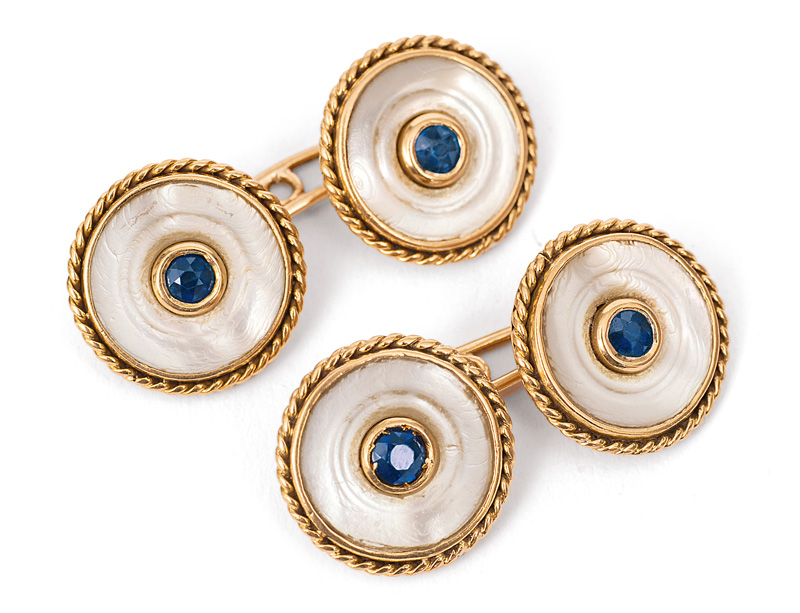 A pair of cuff links with mother-of-pearl and sapphires