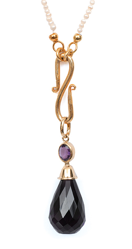 A pearl necklace with a large amethyst pendant