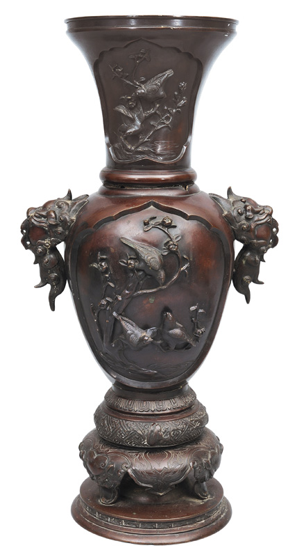 A tall bronze vase with birds relief