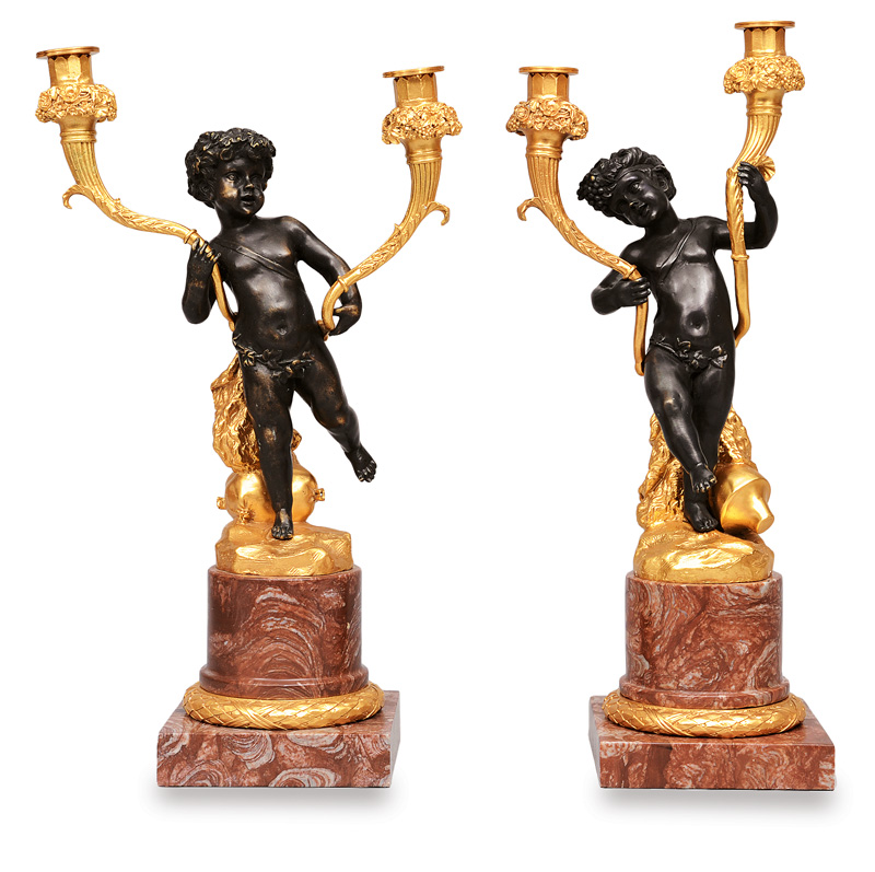 A couple of candleholders with putti