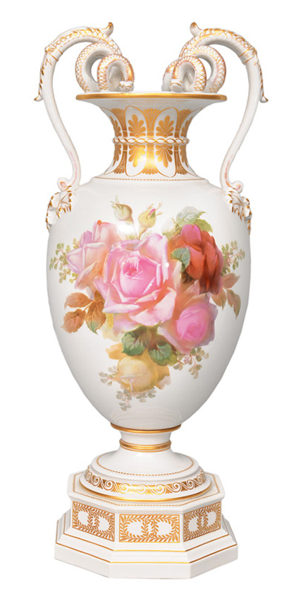 A vase with snake handles and rose bouquet